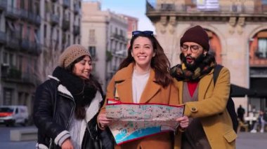 Bir grup turist haritada bir yeri geziyor ve arıyor, bir hafta ve seyahatte yürüyor ve işaret ediyor. Genç gezginler birlikte gülerek şehri ziyaret eden bir rehber arıyorlar. Yüksek