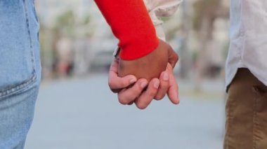 Çok ırklı genç bir çiftin yavaş çekimde el ele tutuşup el ele tutuşmalarını yakından izleyin. Romantik bir randevuda, hassas ve şehvetli bir ilişkiye bağlanan evli çift.