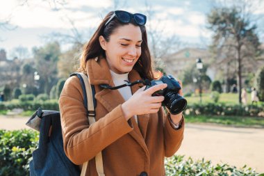 Turist fotoğrafçı kadın az önce Barselona seyahatinde çektiği fotoğrafı görmek için kamerayı izliyor. Jouney gezisinde gezen mutlu genç bir kadın tatilde fotoğraf çekiyor. Yüksek
