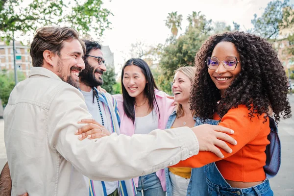 複数の人種の若い大人の人々のグループが結合し 一緒に円上の近さを受け入れる アフリカ系アメリカ人の女性がカメラを見ている 楽しさと笑顔を持つ幸せな同僚のチーム — ストック写真