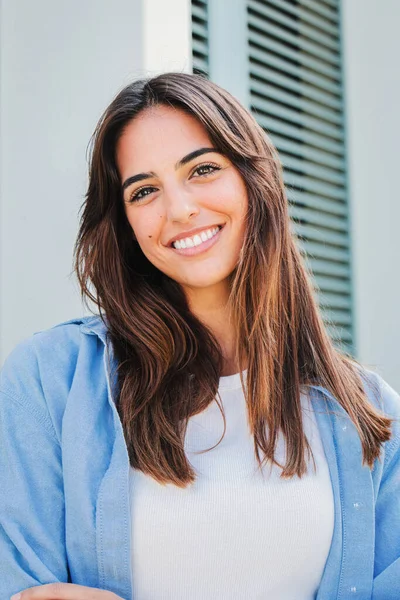 stock image Vertical portrait of a joyful and adorable teenage brunette woman posing for a college promotion with crossed arms. Happy caucasian young student female looking at camera with a perfect white teeth