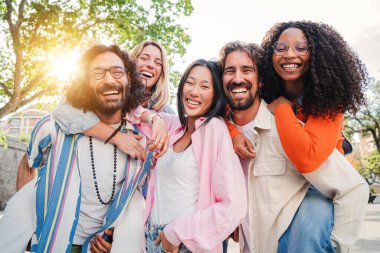En iyi arkadaşlar eğleniyor, gülüyor ve gülümsüyor. Dışarıda selfie çekiyorlar. Uluslararası genç insanlar dostluklarını kutluyorlar. Çok ırklı erkekler dişilere sırtlarını dönerler.
