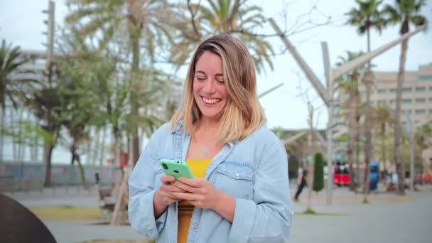 Genç Bir Kadının Cep Telefonu Sosyal Medya Uygulamasını Kullanarak Yürürken — Stok video