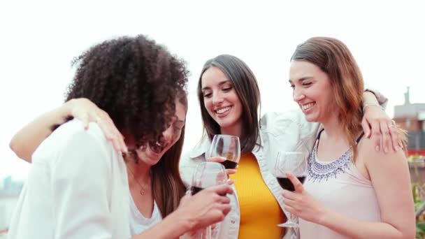 ハッピーな若い女性の友人のグループは 屋上パーティーでワイングラスを飲みながらゴシップを楽しんでいます 楽しい女性は笑顔で ソーシャルイベントで楽しんでいる — ストック動画