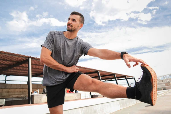 カーディオランニングワークアウト後に脚を伸ばすアクティブスポーティな男 スポットマンは 健康的なライフスタイルを持つフィットネストレーニングルーチンで彼の筋肉を回復します 毎日の強さの練習をしている男 — ストック写真
