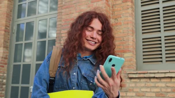 Mutlu Genç Üniversite Öğrencisi Akıllı Telefonunu Sosyal Medyada Mesajlaşmak Için — Stok video