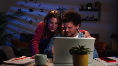 Genç, evli bir çift dizüstü bilgisayar kullanarak emlak almak için geri sayım yapıyor. Alışverişi Huggs 'la kutluyorlar. Mutlu karı kocalar gece geç saatlerde online alışveriş yapıyor. Yüksek