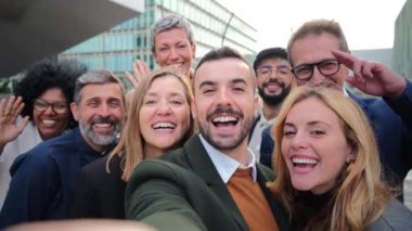 Gülümseyen ve el sallayan bir grup iş adamı. İş adamlarından oluşan bir kalabalık kameraya bakıp selamlıyor. Şirket kurma takımı eğleniyor. İyi giyimli şirket ortakları.