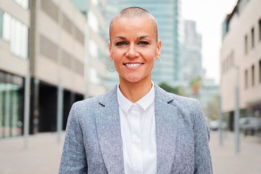 Gülümseyen ve kameraya gururlu bir ifadeyle bakan bir iş kadınının kişisel portresini kapatın. Tezgahtar, temsilci, muhasebeci, avukat ya da yönetici işyerinin önüne bakıyor. Kendine güvenen bir kadın