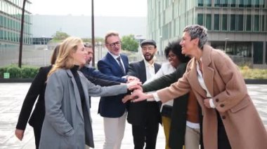 Heyecanlı iş adamları bir başarı ya da başarıyı kutlamak için el ele tutuşuyorlar. Şirket ekibi işbirliği ve destek yapıyor. İş arkadaşları arasında ortaklık, işbirliği, kardeşlik ve destek