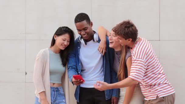 一群年轻的高中生在使用智能手机社交媒体应用程序时大笑着 玩得很开心 大学同学在看手机 朋友们用手机上网 — 图库视频影像