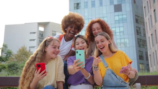 一群使用手机的少女 年轻女人在看她们的智能手机女性朋友在社交媒体上分享手机应用 女士在网上用手机浏览 — 图库视频影像