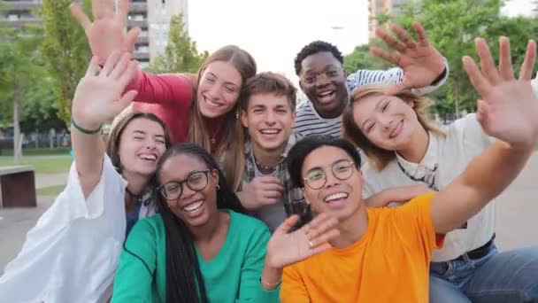 一大群真正的年轻人向你问候 并在假期里玩乐 快乐的朋友们在笑大学生挥手参加社交活动多种族青少年聚会 — 图库视频影像