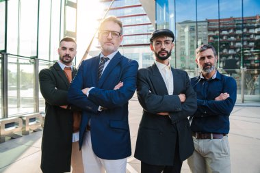 Ciddi ve kendinden emin bir ifadeyle kameraya bakan bir grup gerçek iş adamının portresi. Başarılı erkek iş arkadaşları öne bakıyor. Erkeksi profesyonel insanlar. Şirket ortakları toplantısı