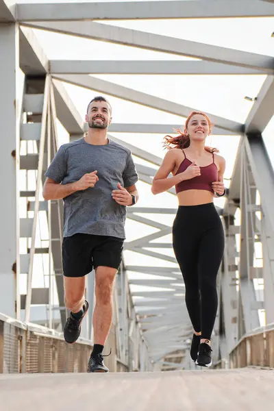 垂直に マラソン レースのための健康 ウェルネス トレーニングのために走る若いカップルは カーディオスポーツを楽しむ努力と持久力を示しています 男性と運動女性のジョギングのワークアウト — ストック写真