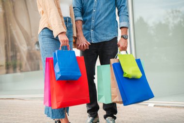 Alışveriş merkezinde alışveriş torbaları taşıyan tanınmamış insanlar. Bir dükkânda ya da butik salonunda elinde hediye olan bir çiftin yakın portresi. Yüksek kalite fotoğraf