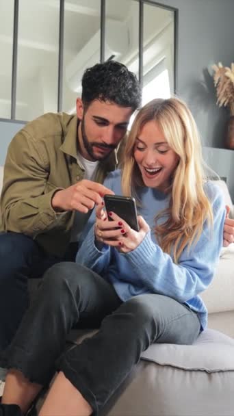 Verticaal Jong Kaukasisch Echtpaar Dat Een Mobieltje Gebruikt Online Boodschappen — Stockvideo