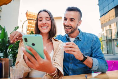 Akıllı telefon bahis uygulamasını izleyen beyaz bir çift. İnternette gezinmek için cep telefonu kullanan iki arkadaş. Gerçek insanlar internetten cep telefonu uygulaması ile alışveriş yapıyor. Sosyal medyada kadın ve erkek