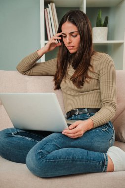 Dikey. Borçlardan dolayı dizüstü bilgisayar kullanan bir kadın finans sorunu yaşıyor. Üzgün, yorgun ve hayal kırıklığına uğramış kadın işinden memnun değil. Stres ve baş ağrısı olan umutsuz bir kadın.