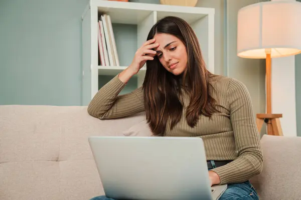 One woman having a finance problem using a laptop overwhelmed with the debts. Sad, tired and frustrated female unhappy with her job having a work trouble. Desperate young lady with stress and headache