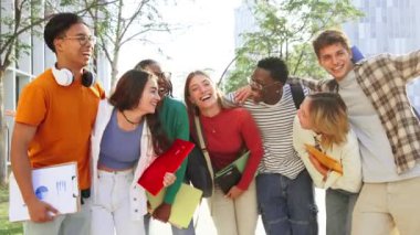 Lisede gülümseyen ve kameraya bakan bir grup gerçek öğrenci. Üniversite kampüsünde gülen mutlu gençler. Dışarıda bekleyen çok ırklı sınıf arkadaşları. En iyi arkadaşlar eğleniyor. Yüksek