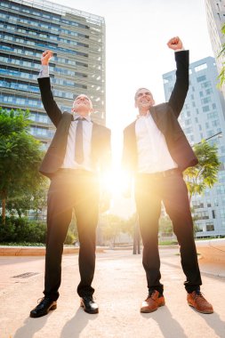 Dikey. Başarılı, olgun iş adamları bir hedefi kutluyor. Hevesli iş adamlarının zaferi. Yönetici erkek başarısı. Kendinden geçmiş orta yaşlı iş arkadaşları zevkle kazanıyor. Yüksek