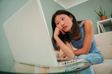 Burnout, anksiyete problemleri olan serbest çalışan bir kadın evde oturuyor. Genç Asyalı kadın dizüstü bilgisayar kullanmaktan yorulmuş, stres ve baş ağrısı çekiyor. Üzgün ve mutsuz öğrenci kız yorgun.