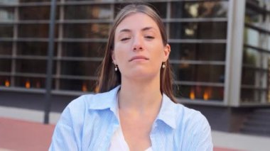 Kendine güvenen, resmi sarışın ve ciddi bir ifadeye sahip bir kadının portresini kapat. Gülümsemeyen gerçek beyaz kız. Genç kız öğrenci kameraya bakıyor. Düşünüyor ve önüne bakıyor.