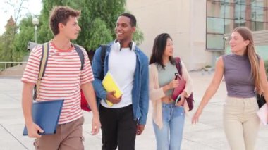 Üniversite kampüsünde yürüyen, gülümseyen ve konuşan dört genç öğrenci. Bir grup genç arkadaş sosyal bir toplantıda sohbet ediyorlar. Çok ırklı insanlar bir toplantıda sohbet ediyorlar.