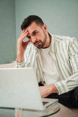 Dikey. Aşırı çalışan adam, borçlarını ve mali durumunu dizüstü bilgisayardan izlemekte zorlanıyor ve hayal kırıklığına uğruyor. İş yorgunluğu çeken üzgün ve yorgun bir erkek. Genç, yetişkin bir adam işi yetiştirmek konusunda stresli. Yüksek