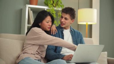 Evdeki kanepede oturan çok ırklı genç çift, bir dizüstü bilgisayarla otel odasını arayıp, rezervasyon yaptırıyor ve tatilleri için uçak bileti alıyorlar. Erkek arkadaş ve kız arkadaş internette bilgisayarla geziniyor.