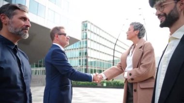 Bir grup iş adamı şirket müşterileriyle olan sözleşmeyi resmileştirmek için iş toplantılarında el sıkışıyor. Yönetici çalışanlar ortaklarına selam veriyorlar. Profesyonel anlaşma. Yüksek