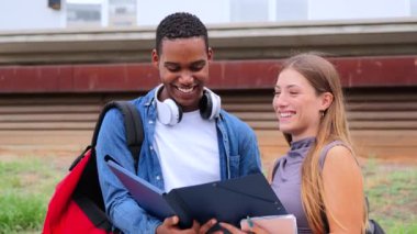 İki çok ırklı öğrenci notlarını birlikte bir defterde gözden geçiriyorlar. Sınıf arkadaşları lisede öğrenilen dersi tartışırlar. Üniversite kampüsünde ders kitabı okuyan bir grup genç. Yüksek