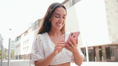 Genç İspanyol kadın internette gezinmek için akıllı telefon kullanıyor. Latin bir kız sosyal medya uygulamasında cep telefonuyla fotoğraf paylaşıyor. Bir kadın dışarıda cep telefonuyla eğleniyor. Yüksek