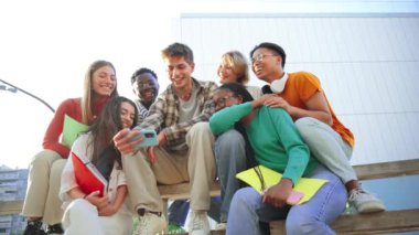 Çeşitli öğrencilerden oluşan bir grup dışarıda oturuyor, birlikte gülüyor ve cep telefonu kullanıyorlar, sosyal medyanın tadını çıkarıyorlar, teknoloji aracılığıyla iletişim kuruyorlar, not defterlerini tutuyorlar ve kampüste anları paylaşıyorlar. Yüksek