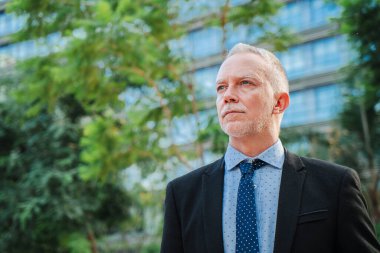 Uzayı kopyala Olgun, deneyimli bir işadamı Ofis Pencereleri 'nden görülebilen yemyeşil çevreye dikkatlice bakar. Yetişkin Erkek Görünüşü Düşünceli ve İçgüdüsel