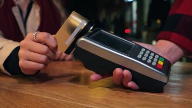 Tanımlanamayan bir müşterinin kredi kartını kullanarak bir kafedeki kart okuyucuya yaptığı ödemenin videosunu çek. Modern ödeme teknolojisini, kolaylığı ve alışverişi vurgula. Yüksek kalite