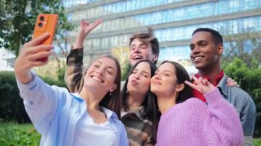 Eğlenceli bir selfie çekerken keyifli bir anın tadını çıkaran, özgün gülümsemeler ve kahkahalar gösteren, Arkadaşlığın ve Neşeli Beraberliğin Özünü Kusursuz bir şekilde yakalayan bir arkadaş grubu