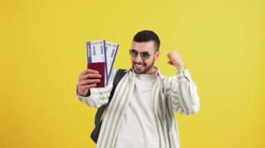 Heyecanlı genç adam elinde pasaport ve uçuş kartlarıyla sevinçli bir tavırla yeni bir maceraya atılmaya hazır bekliyor.