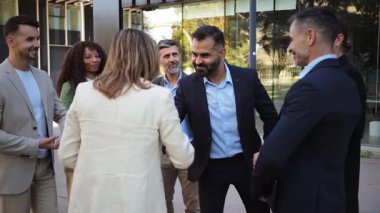 Aralarında erkek ve kadının da bulunduğu çeşitli iş adamları el sıkışma ve selamlaşmaya katılıyor, potansiyel bir iş ortamında profesyonellik ve işbirliği sergiliyorlar.