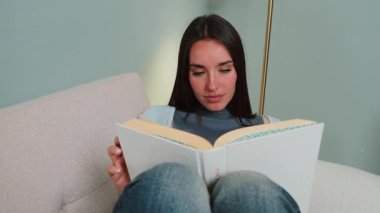 Nişanlı genç bir kadın tamamen ilginç bir kitabın sayfalarına gömülmüş, günlük rutinine ara verirken her kelimenin tadını çıkarıyor, okuma deneyiminde neşe ve sükunet buluyor.