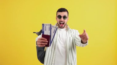 Heyecanlı bir adam elinde pasaportuyla ve uçuş biletleriyle neşeli ifadesinden ve hareketli tavırlarından neşe ve beklentiyle unutulmaz bir seyahat macerasına hazır.