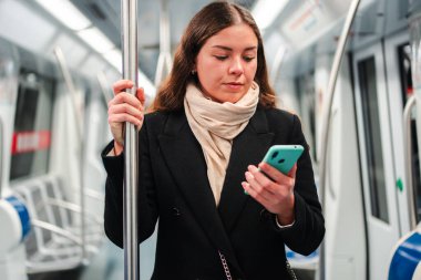 Kendini akıllı telefonuna adamış bir kadın metroda gidip gelirken çeşitli uygulamalarda ustalıkla geziniyor ve cep telefonu teknolojisinin günlük hayattaki temel rolünü sergiliyor.