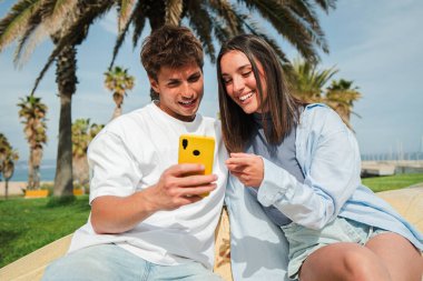 Akıllı telefonlarına göz atan, heyecan verici uygulamaları araştıran ve keyifli bir bağlantı ve keşif anında birbirlerine eşlik eden neşeli bir çift..