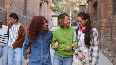 Neşeli bir grup genç arkadaş birlikte yürürken neşeli bir sohbete dalıyorlar, zamanlarının ve paylaştıkları bağın tadını çıkarıyorlar. Gülüşleri arkadaşlığın ve bağlantının neşesini yansıtıyor..