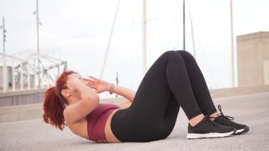 Aktif kadın karın kaslarını çalıştırıyor. Vücut hareketlerini güçlendirmek ve vücut hareketlerini geliştirmek için. Zindelik hedeflerine kararlılık ve enerjiyle ulaşmaya odaklanmış..