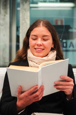 Neşeli kadın yolcu, seyahati sırasında toplu taşıma ile ilgili ilginç bir kitap okumaya daldı. Hikâyeyle tamamen meşguldü ve yeni dünyaları ve fikirleri keşfetme tecrübesinin tadını çıkarıyordu.