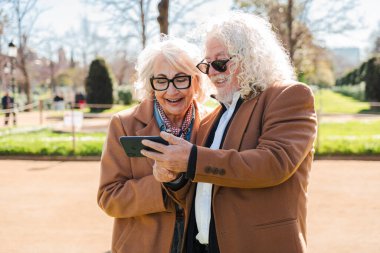 Neşeli bir son sınıf çifti akıllı bir telefonla heyecanlı bir şekilde iletişim kuruyor, eğlenceli uygulamaları keşfediyor ve keyifli anları paylaşıyor, birbirlerine eşlik ediyor, bağlantılarını vurguluyor ve