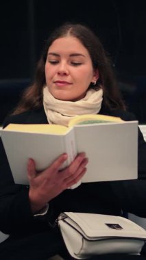 Neşeli kadın yolcu, seyahati sırasında toplu taşıma ile ilgili ilginç bir kitap okumaya daldı. Hikâyeyle tamamen meşguldü ve yeni dünyaları ve fikirleri keşfetme tecrübesinin tadını çıkarıyordu.