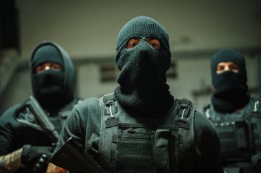 Silahlı ajanların dinamik ve yoğun bir tasviri kritik bir göreve hazır olduklarını ve odaklandıklarını gösteriyor, ellerinde silahlarla kararlılıklarını ve stratejik zihniyetlerini vurguluyorlar.